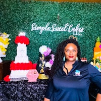 a woman standing in front of a cake display